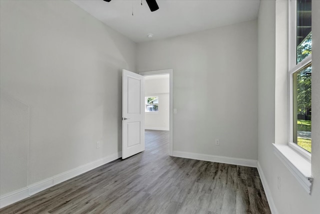 spare room with a healthy amount of sunlight, ceiling fan, and hardwood / wood-style flooring