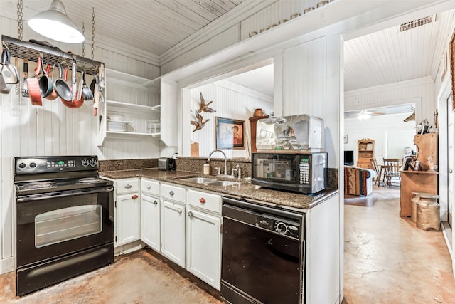 kitchen with sink, dark stone counters, wooden walls, white cabinets, and black appliances