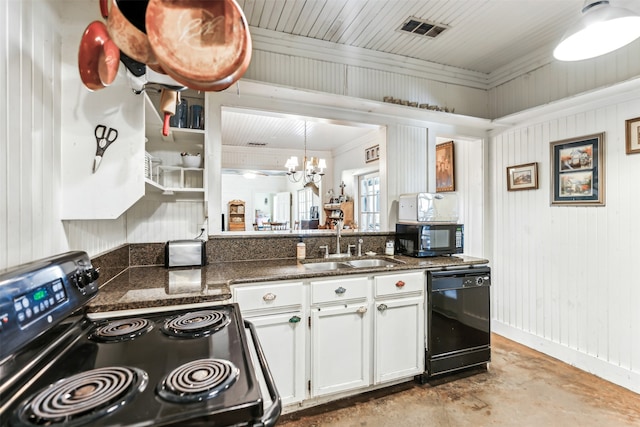 kitchen with sink, black appliances, white cabinets, a chandelier, and wood walls