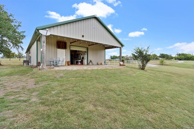 back of property with an outbuilding and a yard