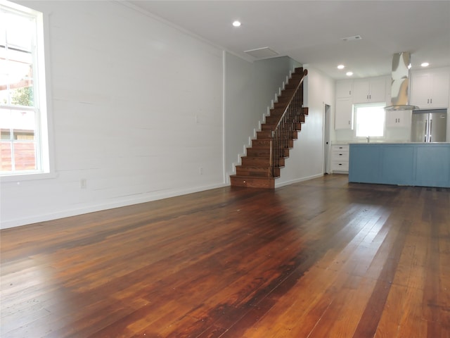 unfurnished living room featuring sink and dark hardwood / wood-style floors