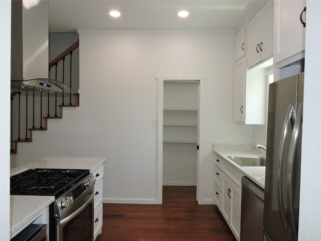 kitchen with appliances with stainless steel finishes, sink, light stone counters, dark hardwood / wood-style floors, and range hood