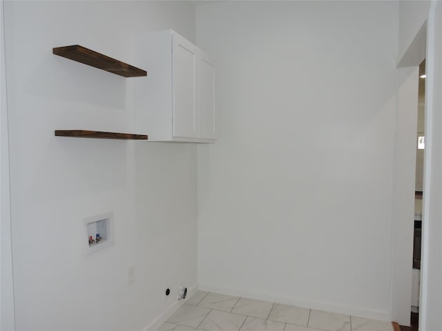 laundry room with light tile patterned flooring, cabinets, and washer hookup