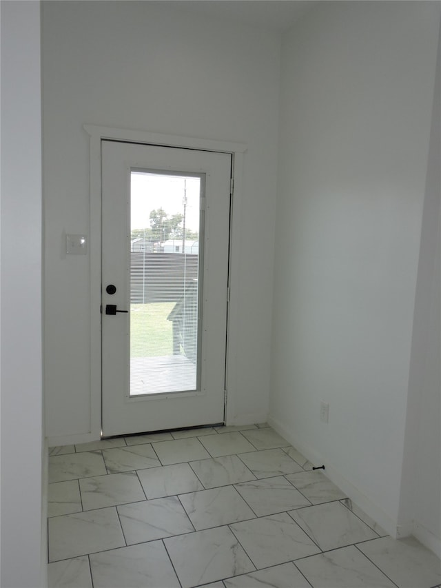 doorway to outside with light tile patterned floors