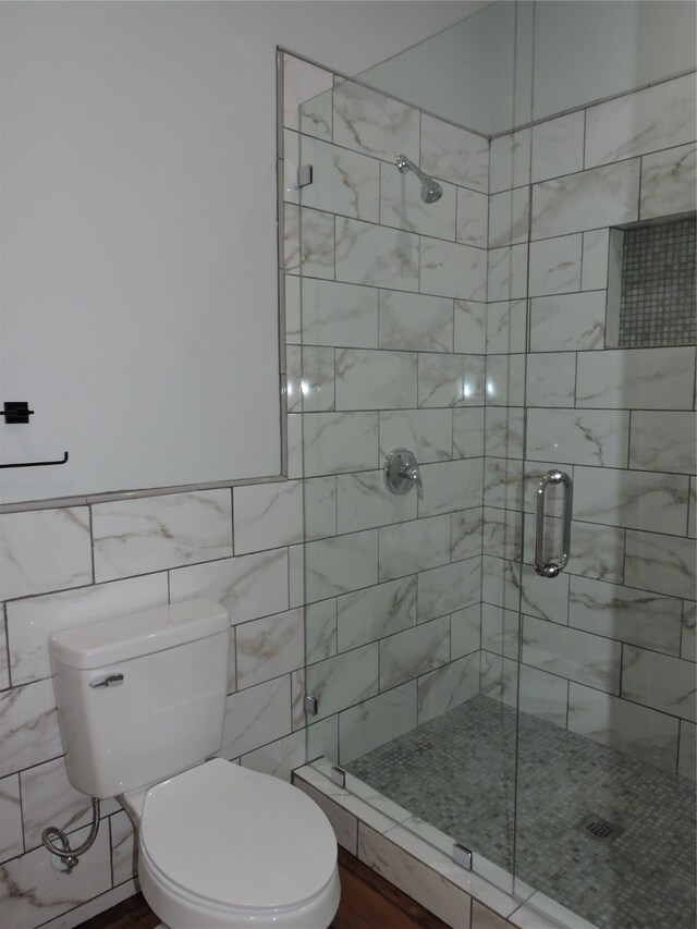 bathroom with walk in shower, tile walls, and toilet