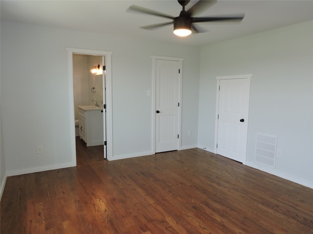 unfurnished bedroom featuring ceiling fan, dark hardwood / wood-style flooring, and connected bathroom