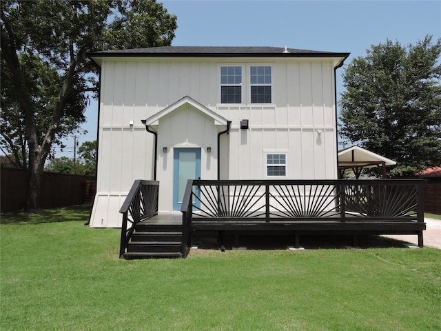 rear view of house with a deck and a lawn