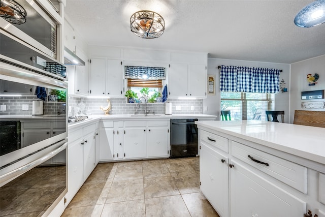 kitchen featuring light tile patterned flooring, decorative backsplash, appliances with stainless steel finishes, and a wealth of natural light