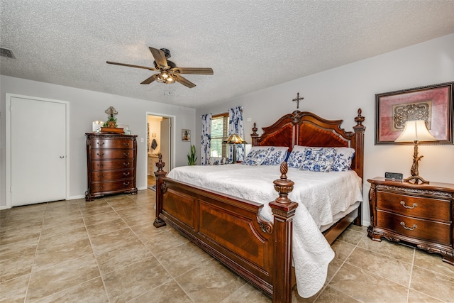 tiled bedroom featuring a textured ceiling, ensuite bath, and ceiling fan