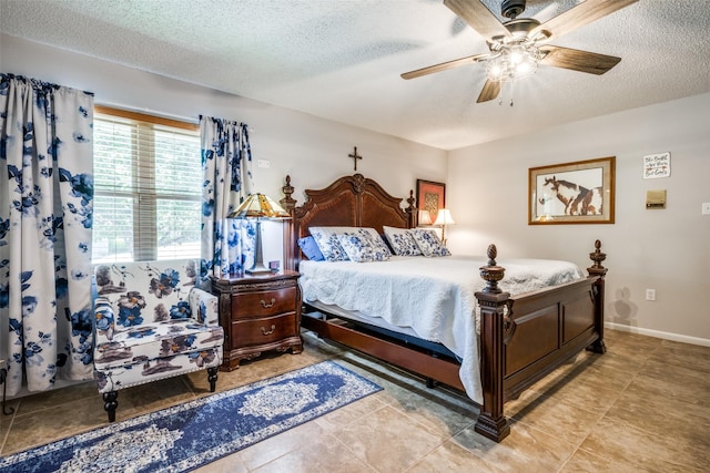 bedroom with ceiling fan, baseboards, and a textured ceiling