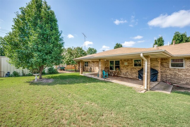 rear view of house with central air condition unit, a lawn, and a patio area