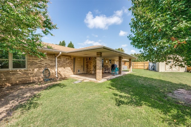 rear view of house with an outbuilding, a patio, a storage shed, brick siding, and a yard