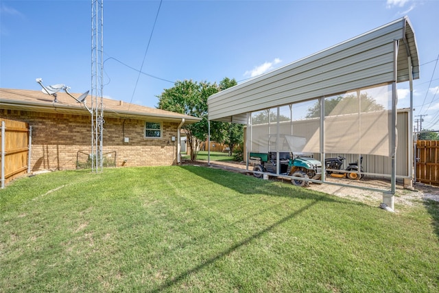 view of yard featuring fence and a detached carport