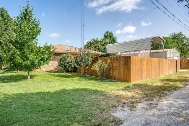 view of yard featuring fence and a carport