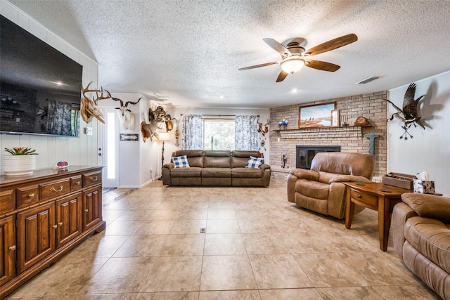 living area with light tile patterned floors, a textured ceiling, visible vents, and a ceiling fan