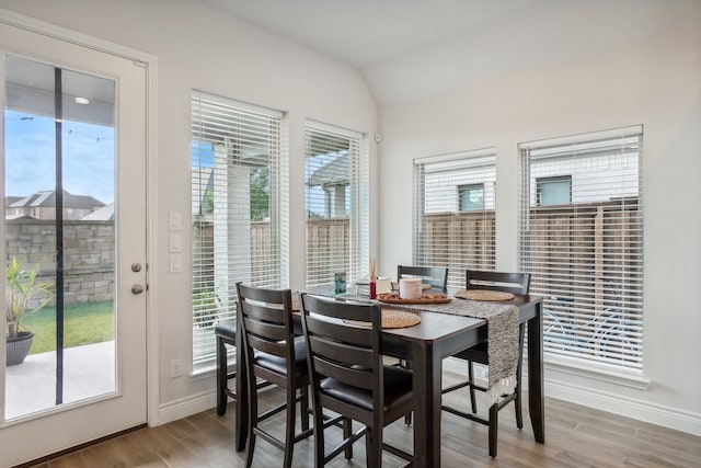 dining area featuring lofted ceiling and light hardwood / wood-style floors