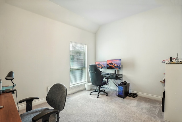 carpeted home office with vaulted ceiling