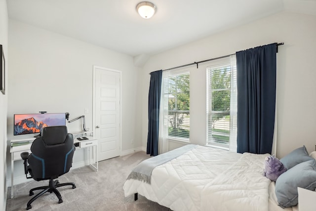 bedroom with lofted ceiling and light colored carpet