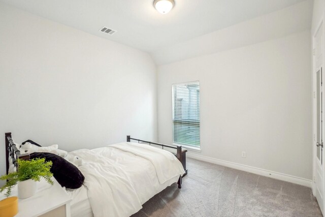 carpeted bedroom with lofted ceiling