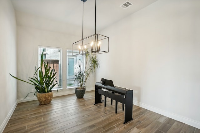 interior space featuring dark hardwood / wood-style floors, a high ceiling, and an inviting chandelier