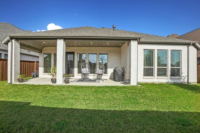 rear view of house featuring a yard and a patio area