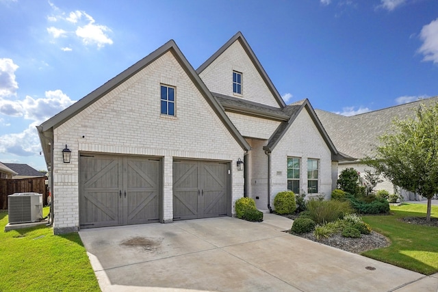 view of front of house featuring a garage, central air condition unit, and a front lawn