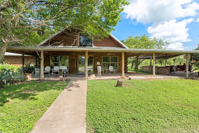 exterior space with a carport and a lawn