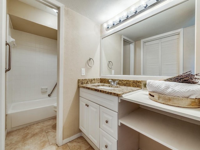 full bathroom with tiled shower / bath, tile patterned flooring, vanity, and toilet