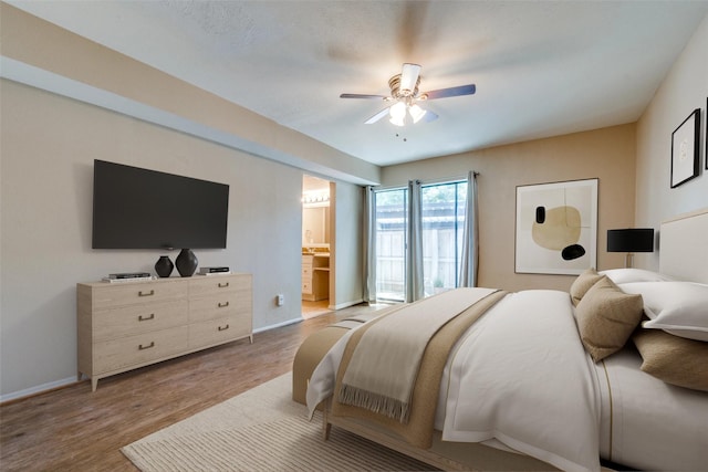 bedroom with light hardwood / wood-style floors, ceiling fan, and ensuite bathroom