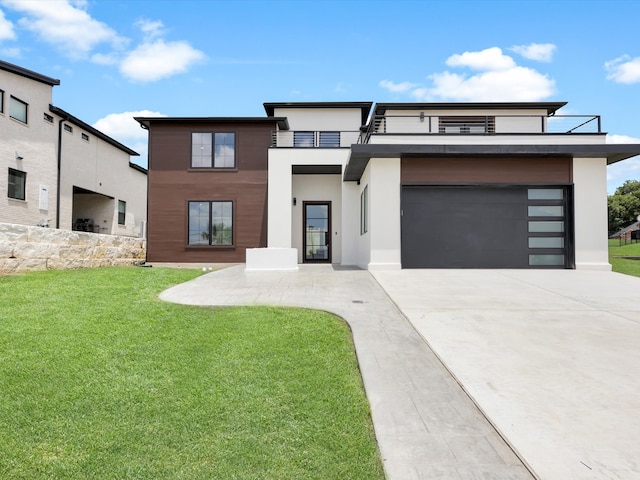 modern home featuring a garage, a balcony, and a front lawn