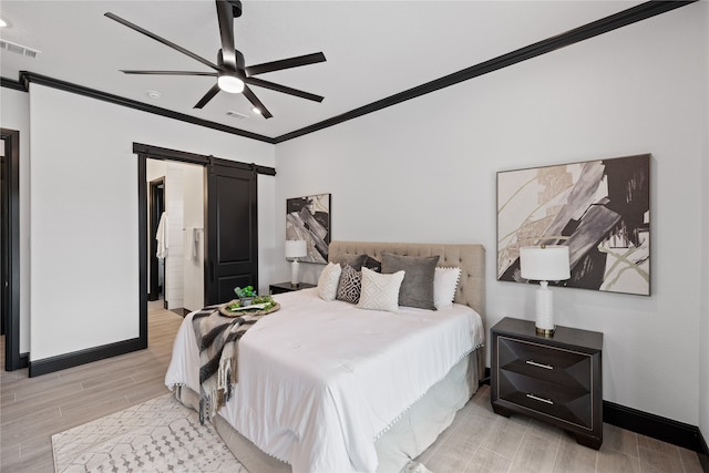 bedroom featuring light hardwood / wood-style floors, ornamental molding, a barn door, and ceiling fan