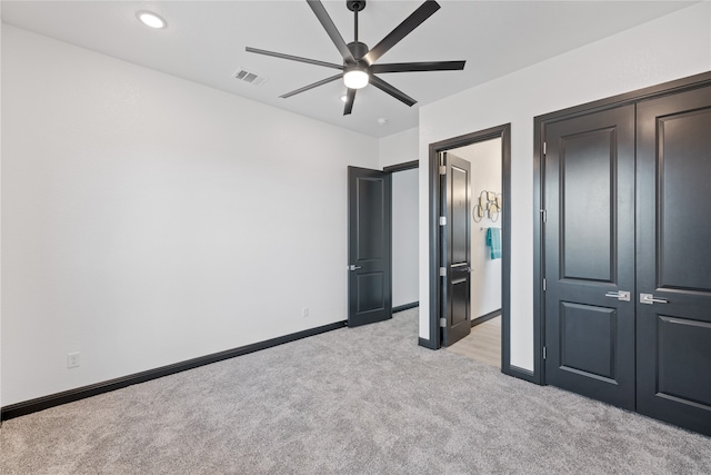 unfurnished bedroom featuring light carpet, a closet, and ceiling fan