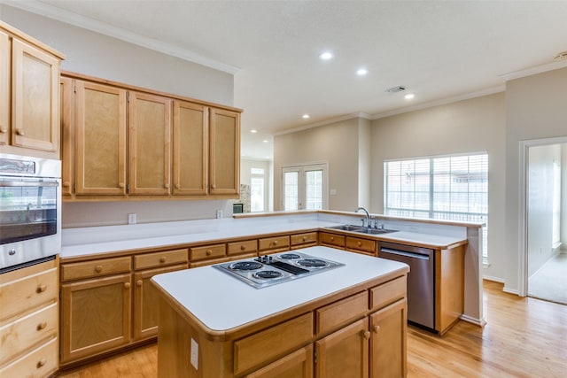 kitchen with sink, appliances with stainless steel finishes, a center island, kitchen peninsula, and light wood-type flooring