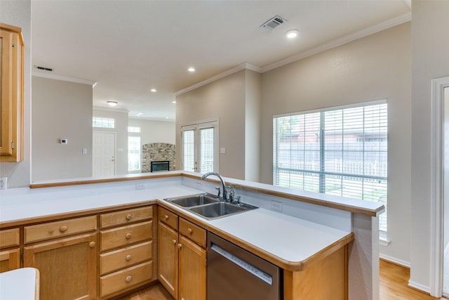 kitchen with a stone fireplace, dishwasher, sink, crown molding, and light hardwood / wood-style flooring