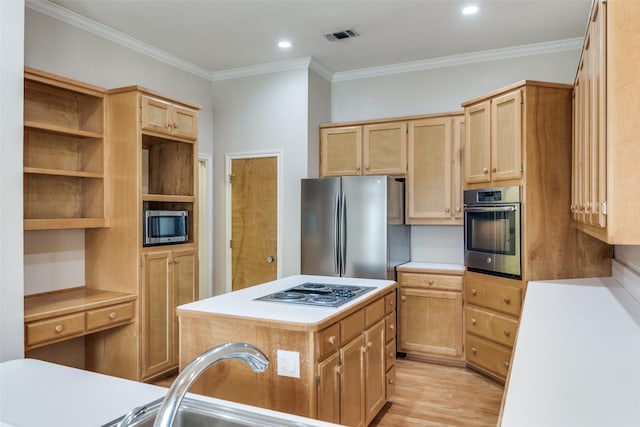 kitchen featuring ornamental molding, appliances with stainless steel finishes, a center island, and light wood-type flooring