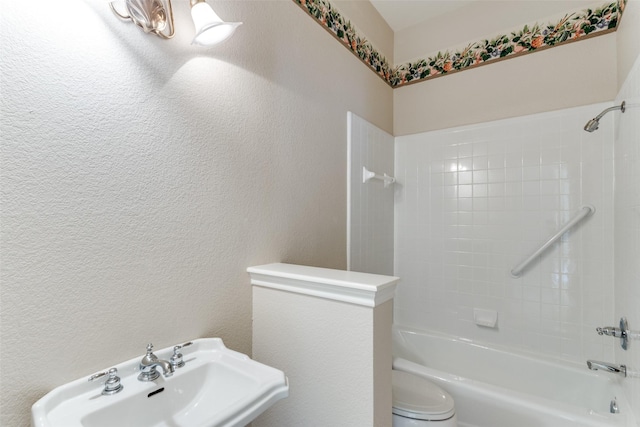 full bathroom with tiled shower / bath, toilet, and sink