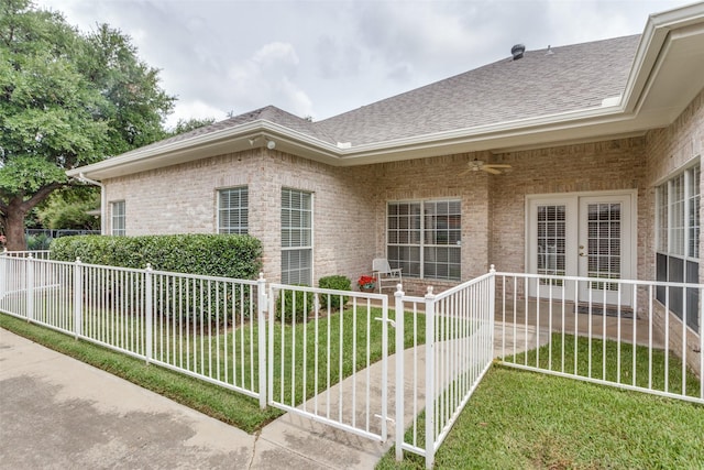 view of home's exterior with french doors, ceiling fan, and a lawn