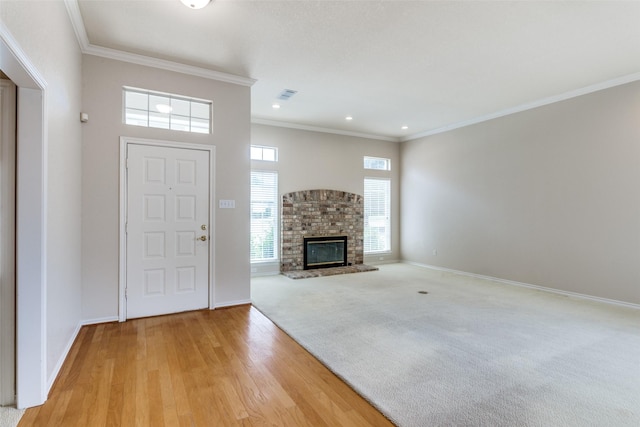 unfurnished living room with ornamental molding, a fireplace, and light hardwood / wood-style flooring