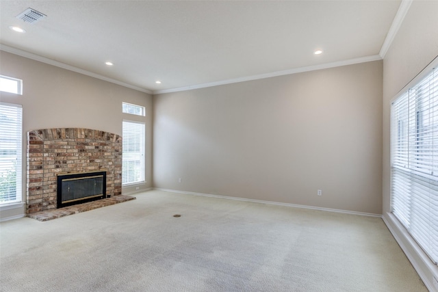 unfurnished living room with light carpet, a brick fireplace, crown molding, and a healthy amount of sunlight