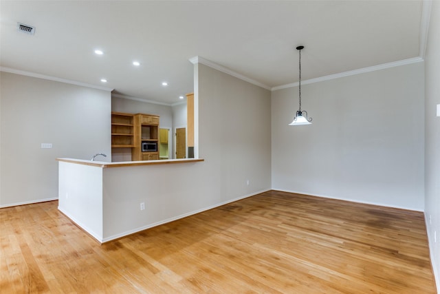 kitchen featuring hanging light fixtures, crown molding, kitchen peninsula, and light wood-type flooring