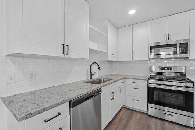 kitchen featuring stainless steel appliances, white cabinets, decorative backsplash, sink, and dark hardwood / wood-style floors