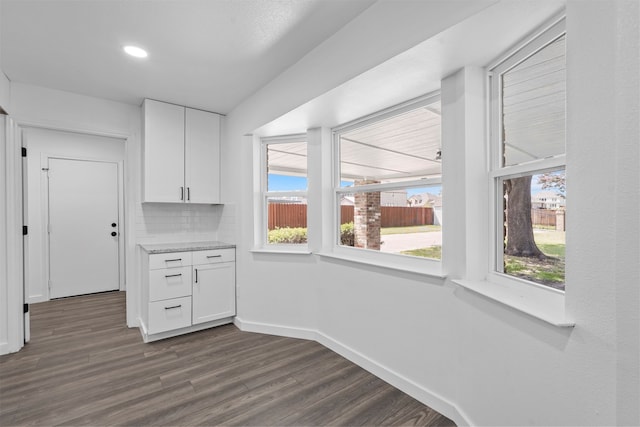 kitchen featuring backsplash, white cabinetry, and dark hardwood / wood-style floors