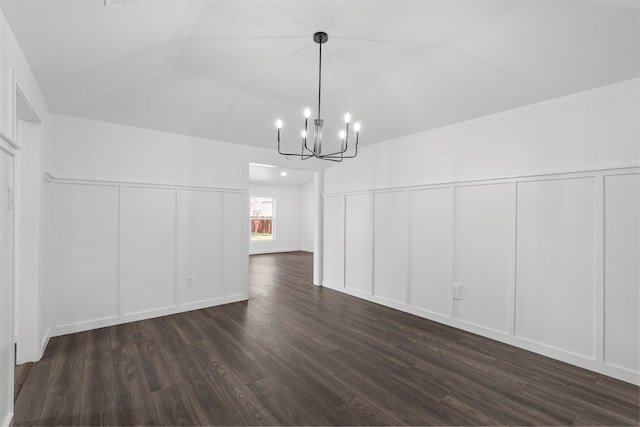 unfurnished dining area with a chandelier, wood-type flooring, and vaulted ceiling