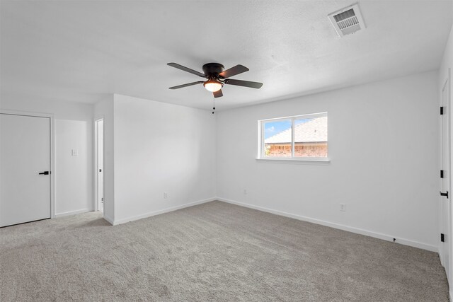 carpeted spare room featuring ceiling fan