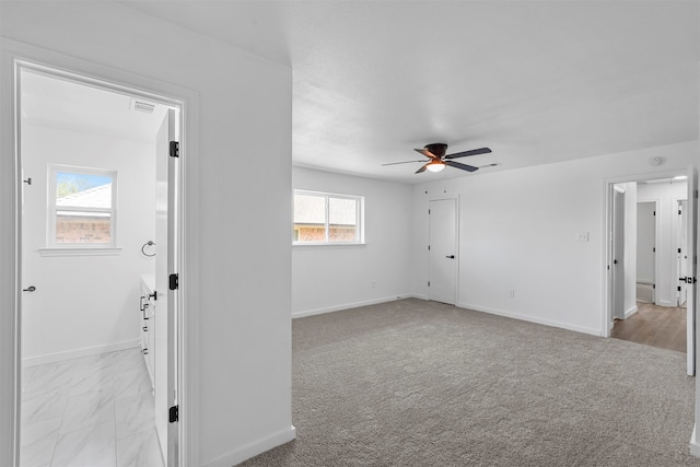 carpeted empty room with a wealth of natural light and ceiling fan