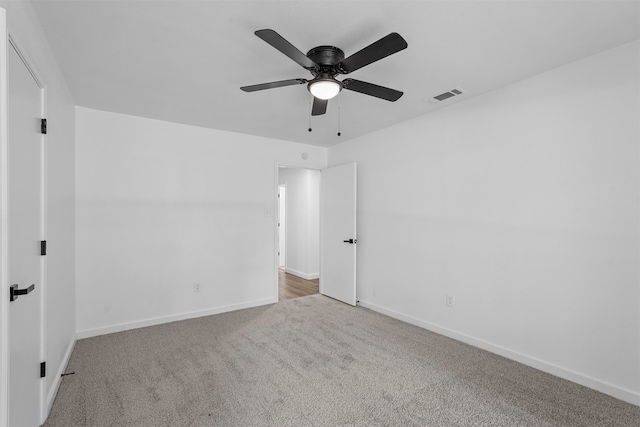 spare room with ceiling fan and light colored carpet