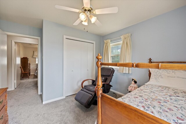 bedroom featuring light colored carpet, a closet, and ceiling fan