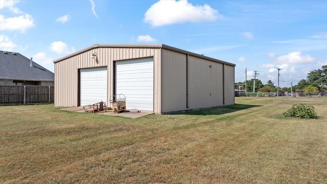 view of outdoor structure featuring a garage and a lawn