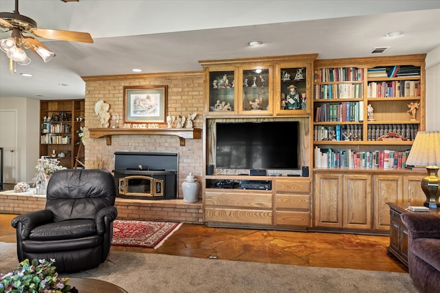 carpeted living room featuring a brick fireplace and ceiling fan