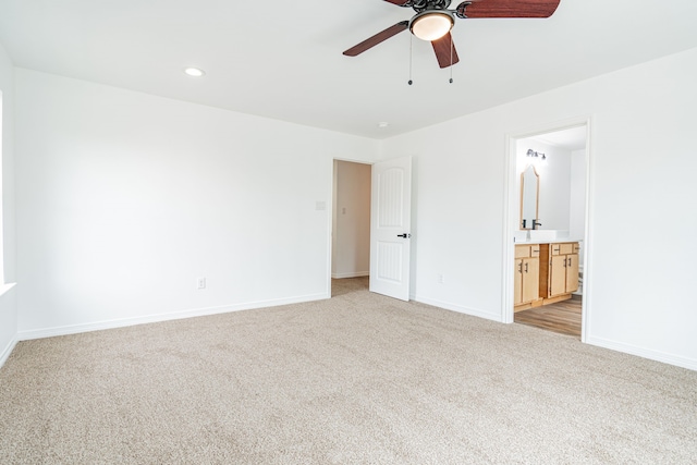 unfurnished bedroom with light colored carpet, ceiling fan, and ensuite bathroom